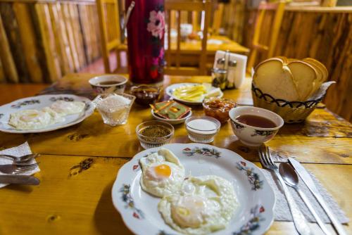 a wooden table with plates of eggs on it at Arista Yurt Camp in Karakol
