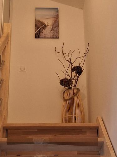 a vase with flowers in it sitting on a shelf at Havre de paix océan et forêt in Mimizan