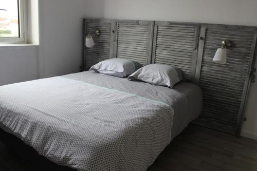 une chambre avec un grand lit avec deux oreillers dans l'établissement L'Appart du Cours, à Roanne