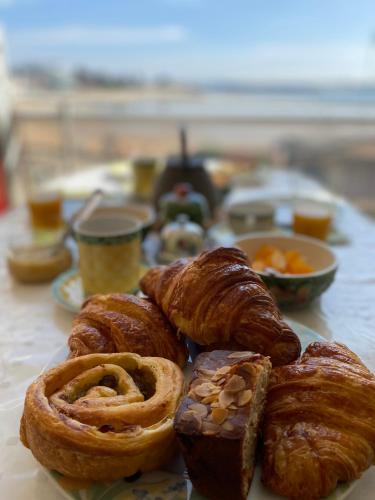 - un plateau de viennoiseries et de pain sur une table dans l'établissement Pleine vue mer et plage, à Larmor-Plage