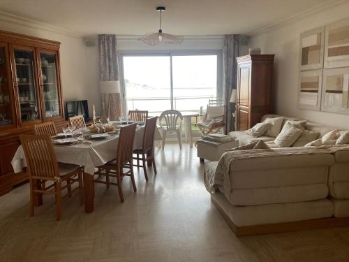 un salon avec un canapé, une table et des chaises dans l'établissement Pleine vue mer et plage, à Larmor-Plage