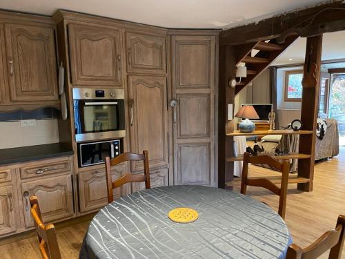 - une cuisine avec des placards en bois et une table dans une pièce dans l'établissement La Libellule, à Les Angles-sur-Corrèze