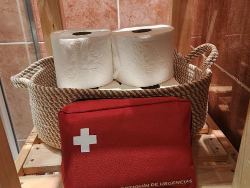 dwie rolki papieru toaletowego w koszyku z czerwonym pudełkiem w obiekcie Piso en Cuzcurrita de Rio Tirón w mieście Cuzcurrita-Río Tirón