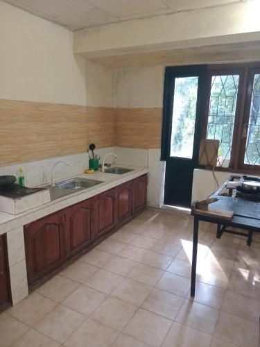 a kitchen with wooden cabinets and a sink and a table at Rock View Holiday Bungalow in Matale