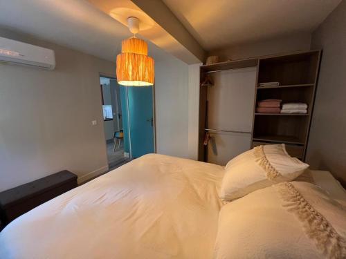 - une chambre avec un lit blanc et une lumière dans l'établissement Les Magnolias 06, à Nice