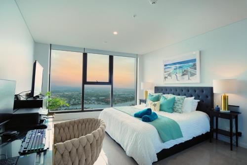 a bedroom with a bed and a desk with a computer at Surfers Beachside Luxury - Stunning Panoramic View in Gold Coast