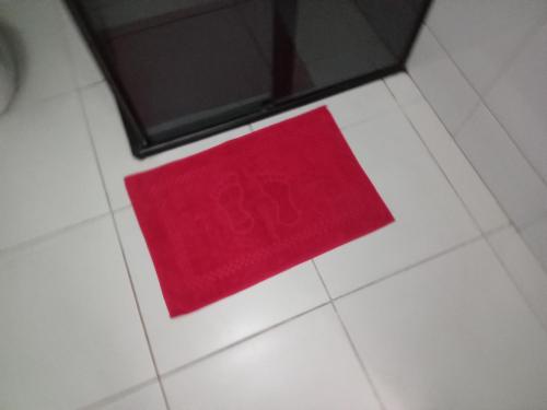 a red napkin sitting on a white tile floor at Casa Balneário Picarras SC in Piçarras