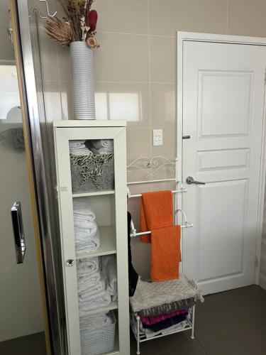 a bathroom with a closet with towels and a door at Whitfords Delight Bed & Breakfast in Perth