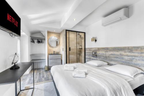 une chambre avec deux lits avec des draps blancs dans l'établissement F3 Centre de Cannes proche du Palais, à Cannes