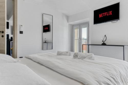 - une chambre blanche avec 2 lits et une télévision murale dans l'établissement F3 Centre de Cannes proche du Palais, à Cannes