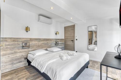 - une chambre blanche avec 2 lits et une table dans l'établissement F3 Centre de Cannes proche du Palais, à Cannes