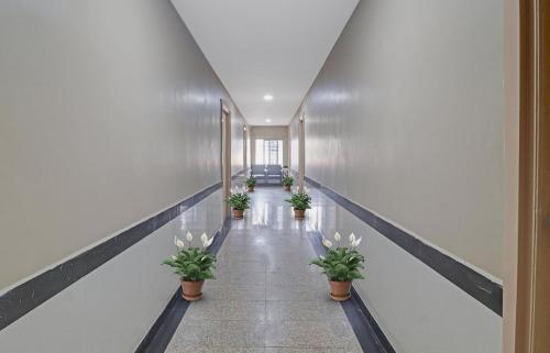 a hallway with potted plants in a building at Hotel O Padmini Near Lakdikapool Metro Station in Hyderabad