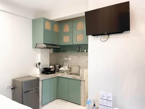 a kitchen with green cabinets and a refrigerator at Caleo Boracay Island Station 3 in Boracay