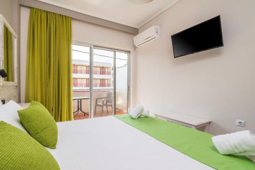 Un dormitorio con una cama con televisión y una ventana. en Silia apartments 2, en Ampavris