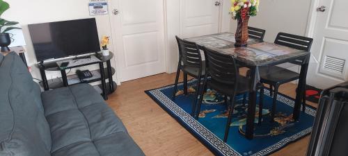 a living room with a table and a tv at Two-Bedroom at San Remo Oasis in Cebu City