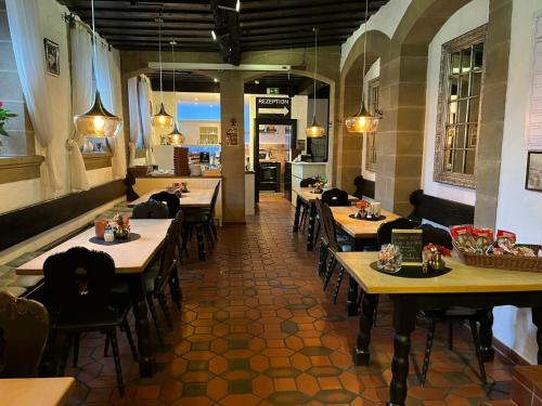 a restaurant with wooden tables and chairs in a room at Hotel Zum Goldenen Anker in Bamberg