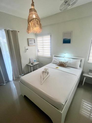a bedroom with a white bed with a towel on it at Caleo Boracay Island Station 3 in Boracay