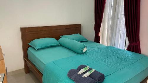 a bed with blue pillows and towels on it at Griya Kania Arjuna in Ngaglik