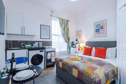 a small bedroom with a bed and a kitchen at Jephsons Lodge Studio 2 - Town Centre Gem, Free Parking in Leamington Spa