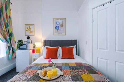 a bedroom with a bed with a plate of fruit on it at Jephsons Lodge Studio 2 - Town Centre Gem, Free Parking in Leamington Spa