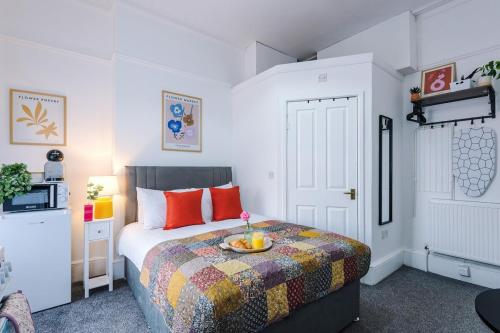 a bedroom with a bed with a bowl of fruit on it at Jephsons Lodge Studio 2 - Town Centre Gem, Free Parking in Leamington Spa