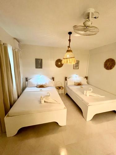 two beds in a bedroom with two swans on them at Caleo Boracay Island Station 3 in Boracay