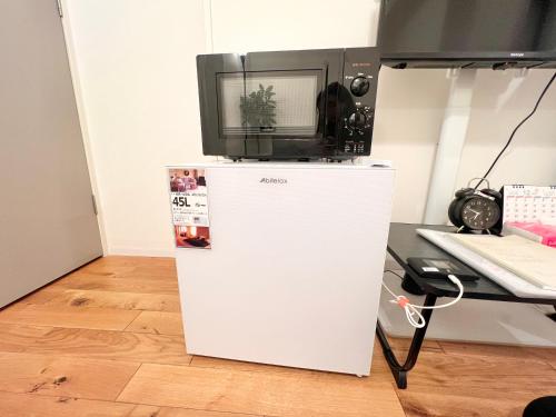 a microwave sitting on top of a refrigerator at FARE Akihabara - Stylish Spacious Studio 8min from Station 201 in Tokyo