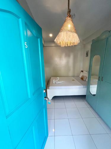 a small room with a bed and a blue door at Caleo Boracay Island Station 3 in Boracay