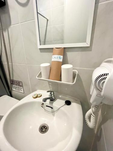 a bathroom with a sink and a toilet and a mirror at Caleo Boracay Island Station 3 in Boracay