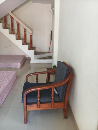 a chair sitting in a room with a staircase at Swanky Midtown Holiday Inn 2BHK in Kolhapur