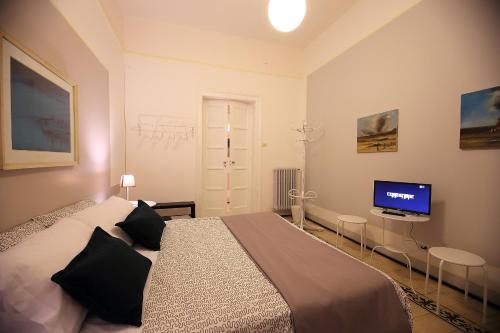 a bedroom with a bed and a flat screen tv at Room and Suite - BARI CENTRALE - in Bari
