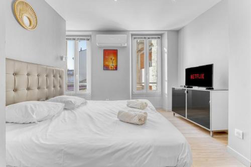 - une chambre blanche avec un grand lit et une télévision à écran plat dans l'établissement F3 Riouffe , Hypercentre à 2minutes du Palais des Festivals, à Cannes