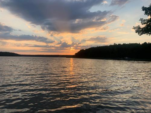 a large body of water with a sunset in the background at Ferienwohnung im Landhaus Labes am Stechlinsee in Stechlin