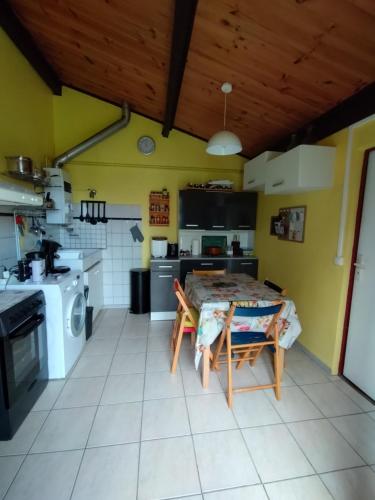 une cuisine avec une table et une cuisine avec une cuisinière dans l'établissement Soulac sur mer - Maison individuelle avec jardin, à Soulac-sur-Mer