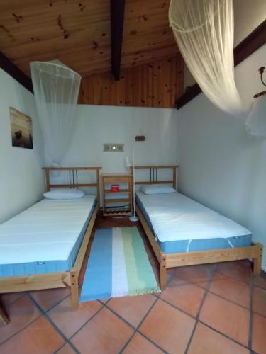 deux lits dans une chambre avec plafonds en bois dans l'établissement Soulac sur mer - Maison individuelle avec jardin, à Soulac-sur-Mer