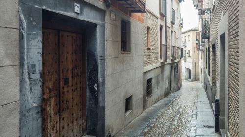 an alley with a wooden door on the side of a building at Apartamento Pozo Amargo Junto a la Catedral by Toledo AP in Toledo