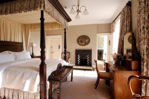 a bedroom with a bed and a desk and a fireplace at Newforge House in Moira