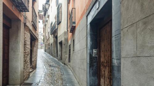 an empty alley way with a wooden door on a building at Apartamento Pozo Amargo Junto a la Catedral by Toledo AP in Toledo