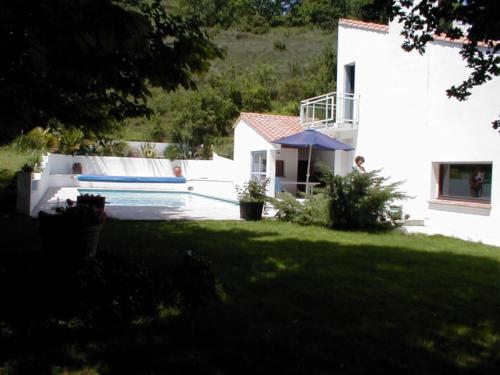 a white house with a swimming pool in a yard at Maison de campagne avec lac privé in Fendeille