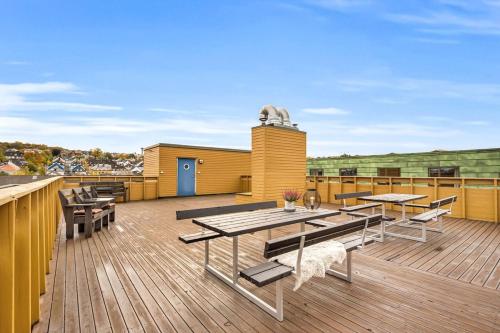 Una terraza con mesas y sillas en un edificio. en Penthouse in Trondheim, Solsiden, en Trondheim