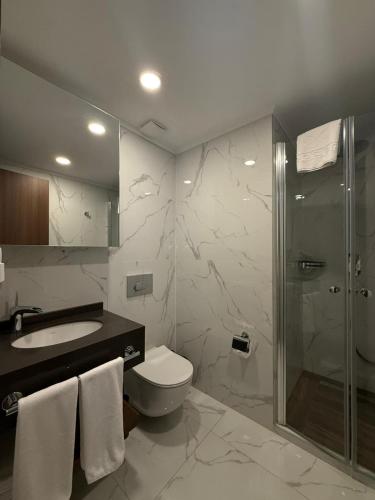 a bathroom with a shower and a toilet and a sink at Grand sapphire resort Ötüken yeni iskele North Cyprus in Trikomo