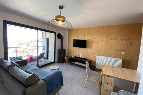 a living room with a couch and a table at 06CI Beautiful T2 apartment with terrace - Valberg in Valberg