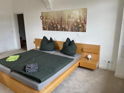 a bedroom with a bed with green sheets and pillows at Wohnen in der alten Max Selbmann Villa in Hohenstein-Ernstthal