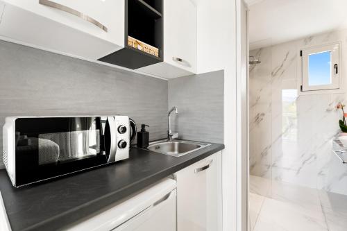 a kitchen with a microwave and a sink at Frunze Luxury Apartments in Nafplio