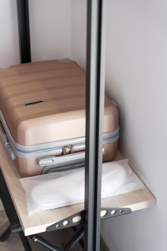 two pieces of luggage on a shelf in a closet at Frunze Luxury Apartments in Nafplio