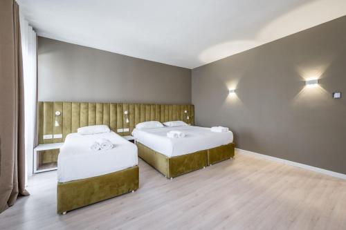 two beds in a room with a window at Ajsel Hotel in Durrës