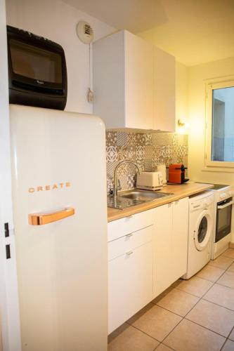 La cuisine blanche est équipée d'un évier et d'un réfrigérateur. dans l'établissement Spacieux 2 pièces avec place de parking , la Villette, à Aubervilliers