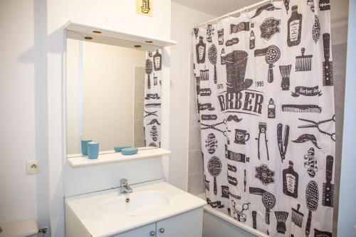 une salle de bain avec un lavabo et un rideau de douche dans l'établissement Spacieux 2 pièces avec place de parking , la Villette, à Aubervilliers