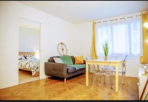 un salon avec une table et un canapé dans l'établissement Spacieux 2 pièces avec place de parking , la Villette, à Aubervilliers