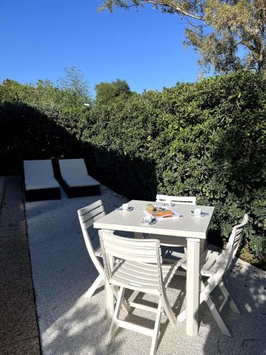 哥斯达雷Villetta Solemari - 100m from the beach的 ⁇ 边的白色桌子和椅子